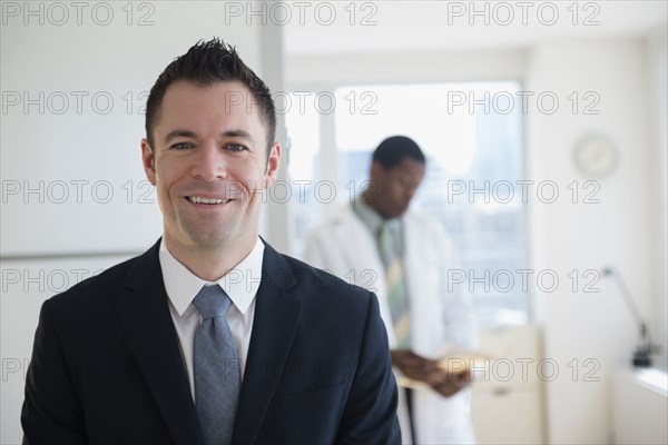Businessman smiling in office with doctor