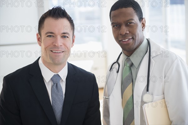 Businessman and doctor smiling in office