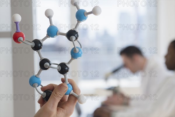 Close up of scientist holding molecular model in lab