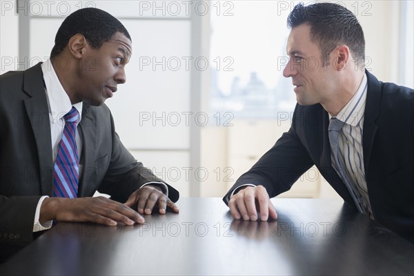 Businessmen talking in office meeting