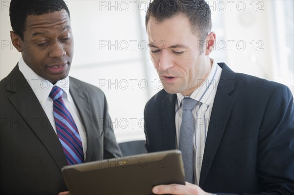 Businessmen using digital tablet in office