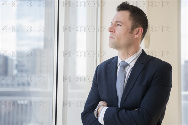 Businessman looking out office window