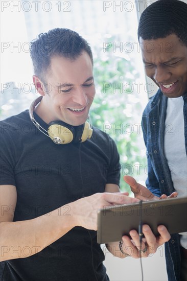 Close up of men sharing digital tablet