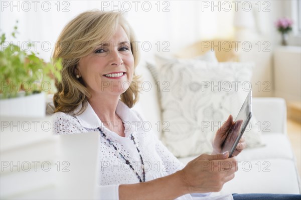 Caucasian woman using digital tablet on sofa