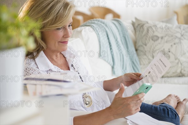 Caucasian woman paying bills online on cell phone