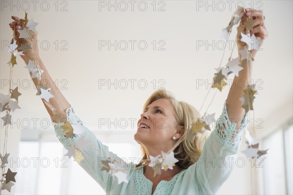 Caucasian woman decorating with garland in living room
