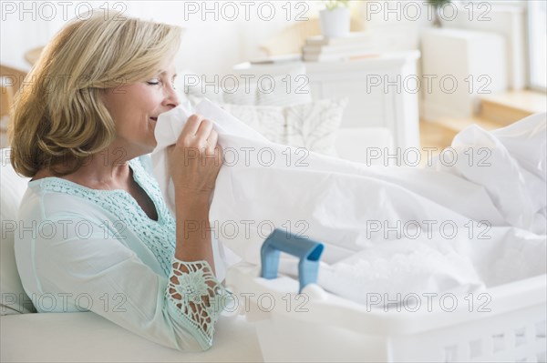 Caucasian woman smelling clean laundry