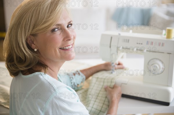 Caucasian woman using sewing machine