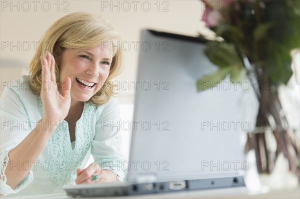 Caucasian woman video chatting on laptop