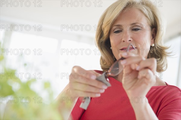 Caucasian woman cleaning eyeglasses