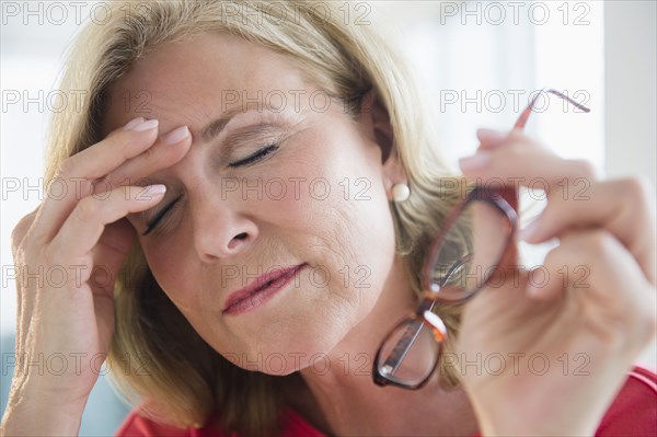 Stressed Caucasian woman rubbing forehead