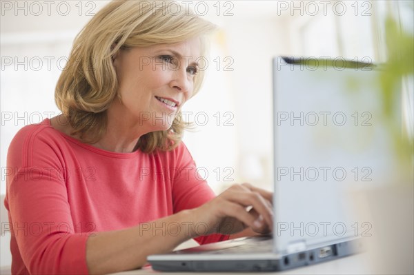 Caucasian woman using laptop at desk