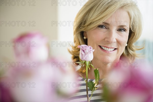 Caucasian woman holding pink rose
