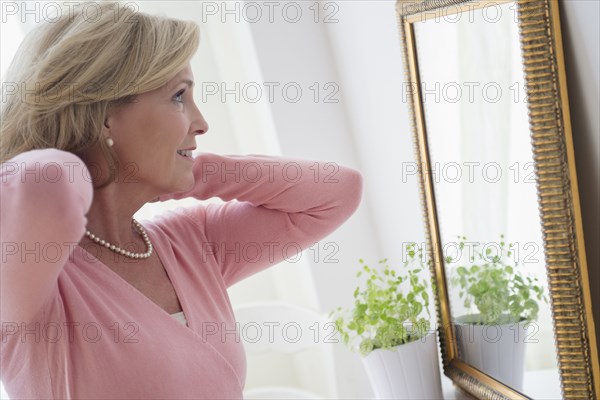 Caucasian woman admiring herself in mirror