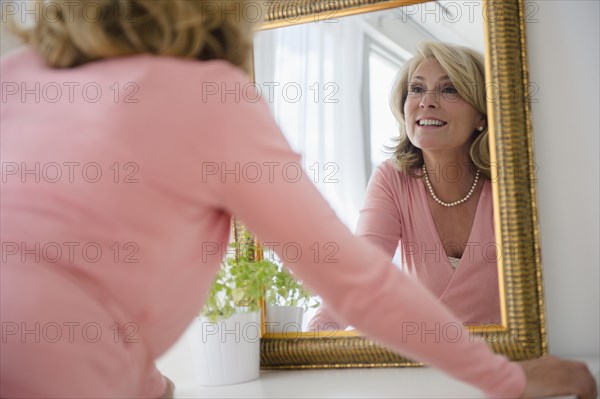 Caucasian woman admiring herself in mirror