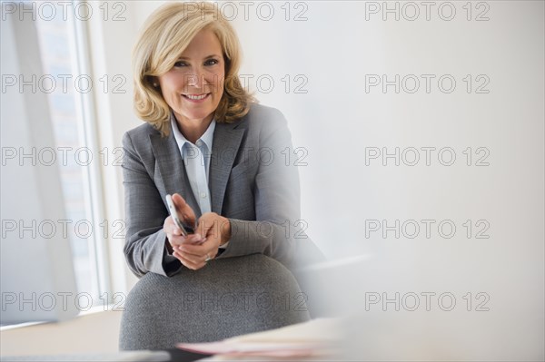 Caucasian businesswoman smiling in office