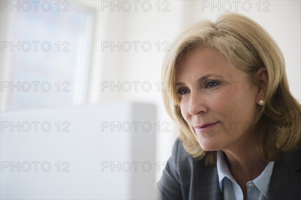 Caucasian businesswoman working on computer in office