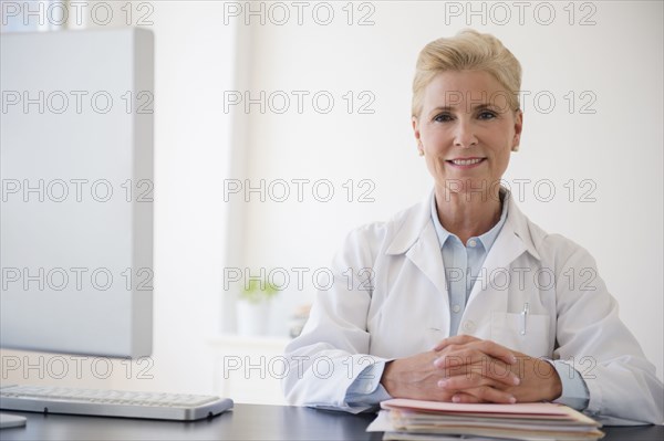 Caucasian doctor sitting at office desk