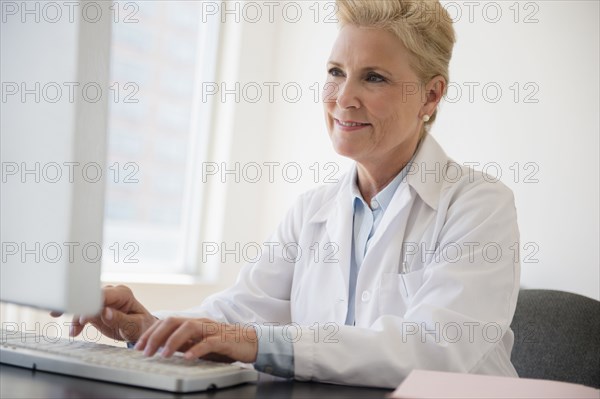 Caucasian doctor working at computer in office