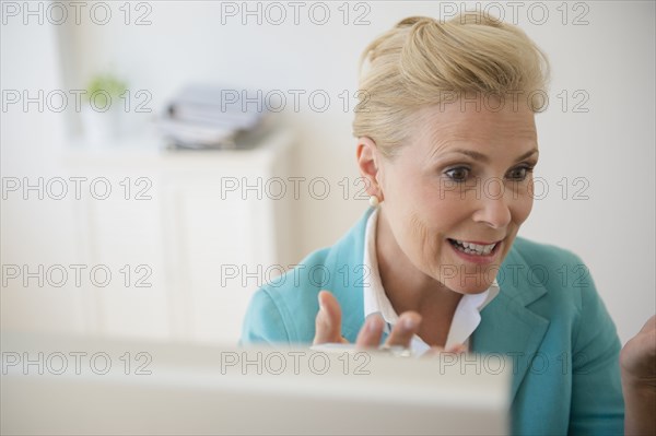 Caucasian businesswoman working at computer in office