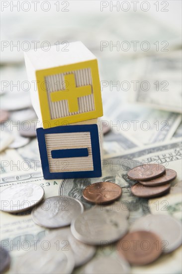 Close up of plus and minus toy blocks with money