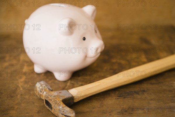 Close up of piggy bank and hammer on table