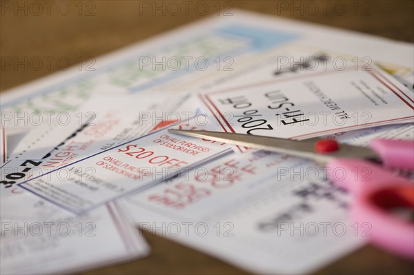 Close up of coupons and scissors on table