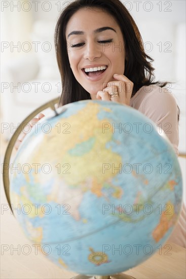 Woman admiring globe on desk