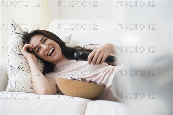 Woman watching television on sofa