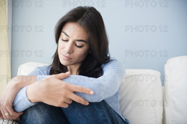 Sad woman sitting on sofa