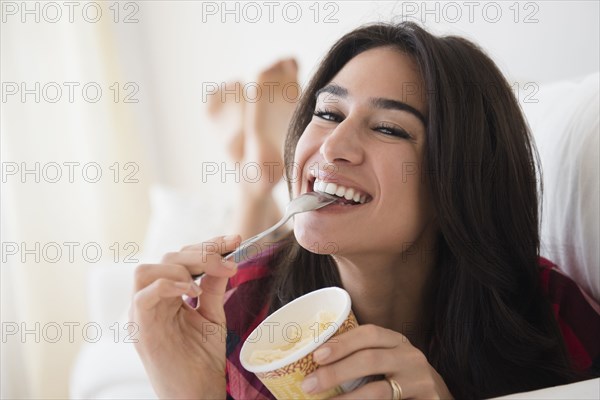 Close up of woman eating ice cream on sofa