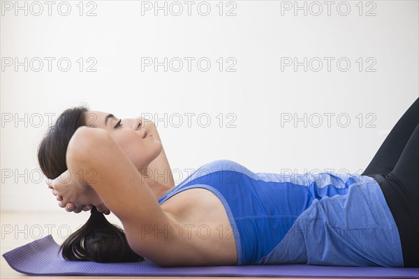 Woman doing crunches on exercise mat