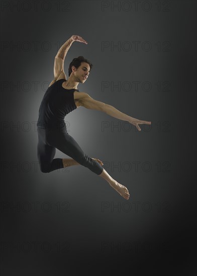 Hispanic ballet dancer leaping in mid-air