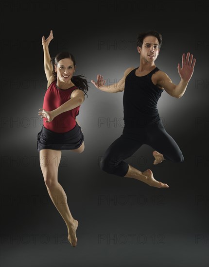 Hispanic dancers leaping in mid-air