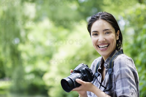 Hispanic woman photographing outdoors