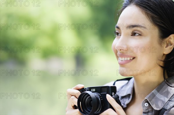 Hispanic woman photographing outdoors