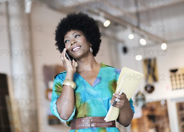 African American business owner talking on cell phone in store
