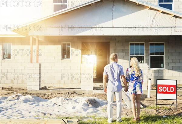 Caucasian couple admiring new home