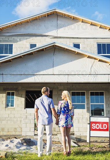 Caucasian couple admiring new home