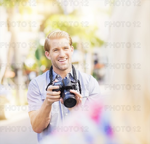 Caucasian photographer photographing woman outdoors