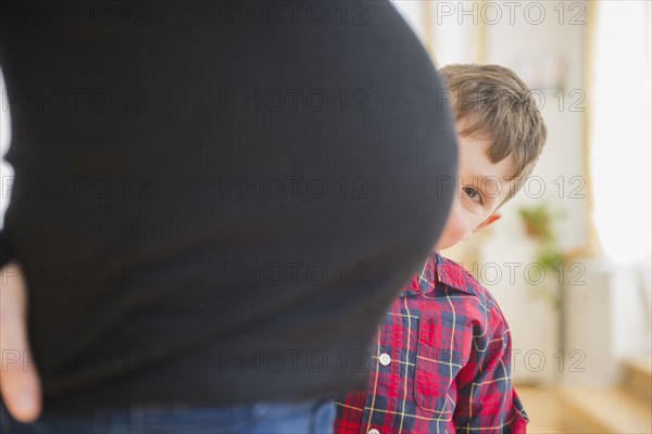 Boy admiring belly of pregnant mother