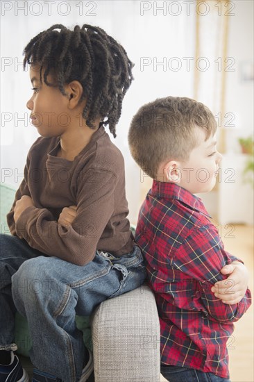 Boys arguing on living room sofa