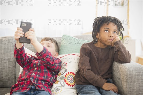Boy with cell phone ignoring friend