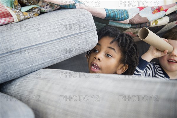 Boys playing in pillow fort