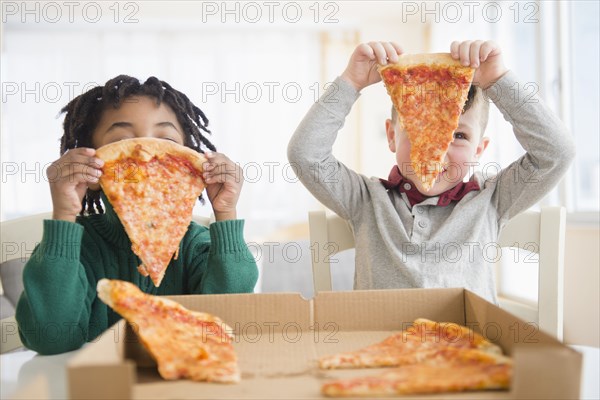 Boys eating pizza from cardboard box