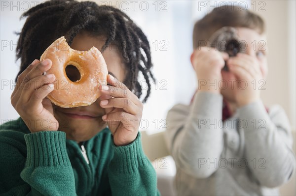 Boys peering through donut holes