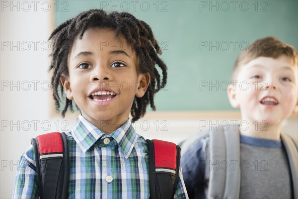 Students wearing backpacks in classroom