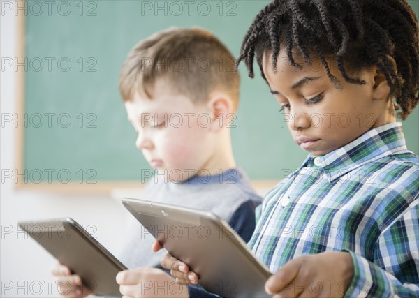 Students using digital tablet in classroom