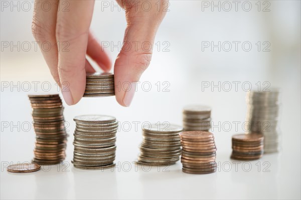 Mixed race woman stacking coins