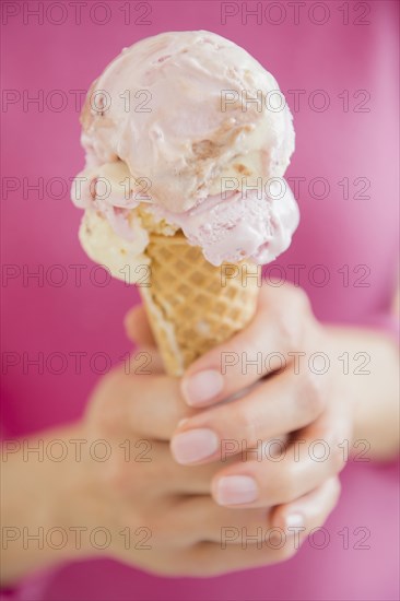Mixed race woman holding ice cream cone